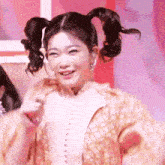 a woman with pigtails is smiling and holding a piece of paper .