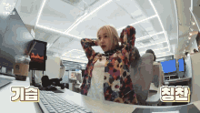 a woman sits at a desk with her hands behind her head and a starbucks coffee cup in front of her