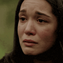 a close up of a woman 's face with tears running down her cheeks