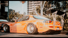 an orange sports car with a license plate that says california on it is parked on the sidewalk