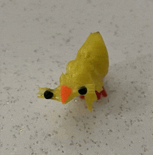 a yellow plastic toy with black eyes and orange beaks