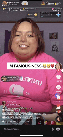 a woman in a pink shirt with the words im famous-ness