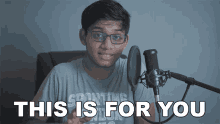 a young man stands in front of a microphone with the words " this is for you " below him