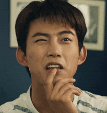 a close up of a man making a funny face with his hand on his chin