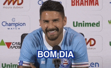 a man in a blue shirt with the word bom dia on the front