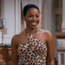 a woman is wearing a leopard print dress and smiling .