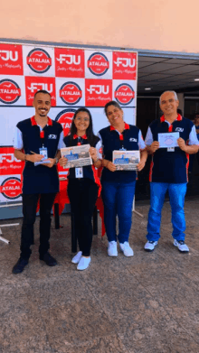 a group of people holding newspapers in front of a backdrop that says fju