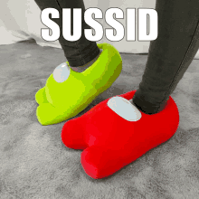 a person wearing green and red among us slippers with the word sussid on the bottom