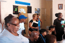 a group of people are gathered in a room with a sign that says majority women 's group