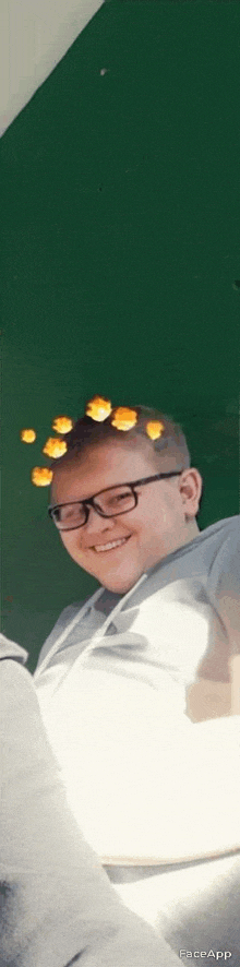 a young man wearing glasses and a crown of flowers on his head