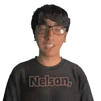 a man wearing glasses and a nelson shirt smiles