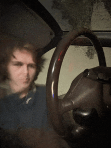 a blurry picture of a man behind the steering wheel of a car