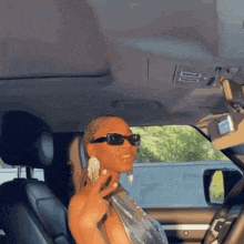 a woman wearing sunglasses is sitting in a car .