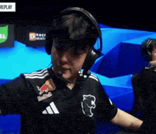 a man wearing headphones and a black redbull shirt