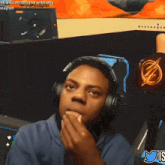 a man wearing headphones and a shirt with a lightning bolt on it is playing a video game