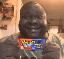 a man is holding a reese 's oreo bar