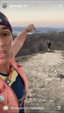 a woman taking a picture of herself on top of a mountain with the name gosonja on the bottom