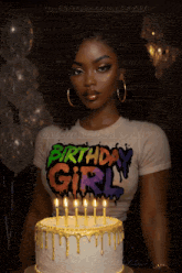 a woman in a birthday girl shirt stands in front of a birthday cake
