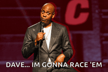 a man in a suit stands in front of a microphone with the words dave im gonna race em below him