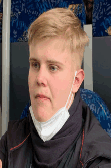 a young man wearing a face mask and scarf