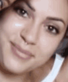 a close up of a woman 's face with a blurred background .