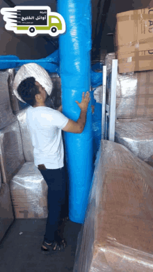 a man in a white shirt is holding a blue tarp with arabic writing on it