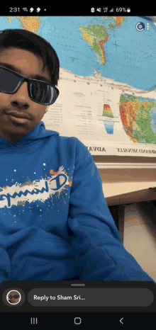 a boy wearing sunglasses and a blue champion sweatshirt