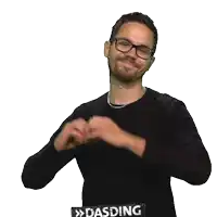a man wearing glasses and a black sweater is making a heart shape with his hands in front of a sign that says dasding