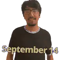a man wearing glasses and a black shirt with the date september 14 on it