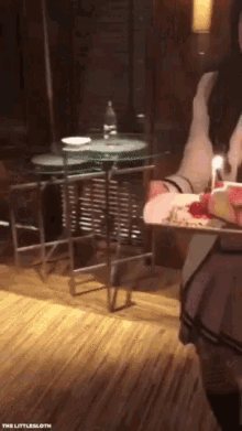 a waitress is holding a tray of food in front of a table with a bottle of water on it