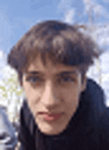 a close up of a young man 's face with a blurred background .