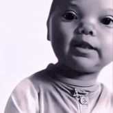 a baby is wearing a white shirt with a zipper on the front