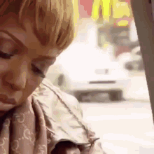 a woman is sitting in a car with her eyes closed and a mcdonald 's in the background .