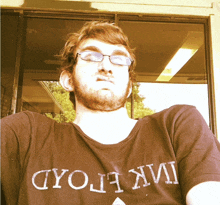 a man wearing glasses and a t-shirt that says " ink xvi "