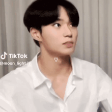 a young man in a white shirt has a heart on his neck and a tiktok account