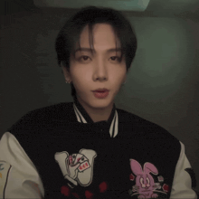 a man wearing a black and white jacket with a pink bunny on it