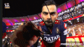 a man wearing a qatar airlines jersey holds a rope in his hand