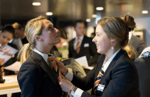 two women in suits and ties with one wearing a name tag that says ' nl '