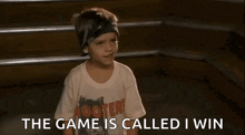 a young boy wearing a hooters t-shirt is sitting on a set of stairs and talking .