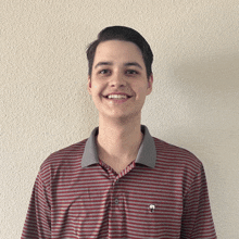 a young man wearing a red and white striped polo shirt smiles