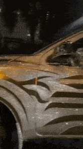 a close up of a car 's fender with a swirl design on it