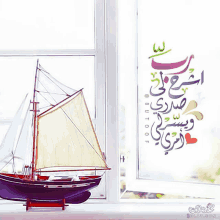 a model sailboat sits in front of a window with arabic writing