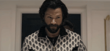 a man with a beard wearing a black and white shirt