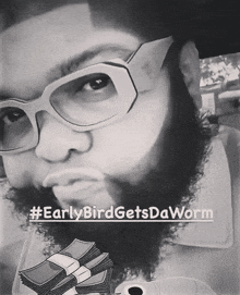 a man with a beard is wearing glasses and holding a stack of money with the caption #earlybirdgetsdaworm