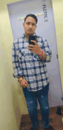a man taking a selfie in front of a door that says floral