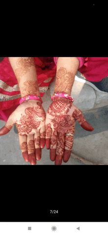 a close up of a woman 's hands with henna on them and the date 7/24