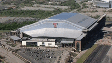 an aerial view of a large building with a large t on the top