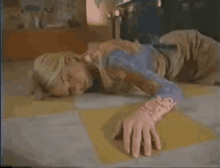 a woman is laying on the floor with her hands on her face