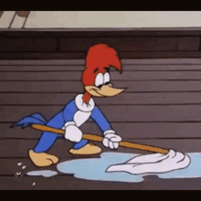 woody woodpecker is cleaning the floor with a mop and a cloth .