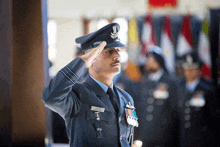 a man in a military uniform salutes while wearing a name tag that says ' shree ' on it